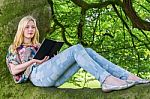 Girl Lying On Tree Reading Book Stock Photo