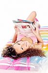 Girl Reading Magazine On Air Mattress Stock Photo