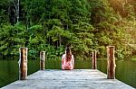 Girl Sitting Alone On A The Wooden Bridge On The Lake. Pang Ung, Thailand Stock Photo