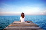 Girl Sitting Alone On A The Wooden Bridge On The Sea. (frustrated Depression) Stock Photo
