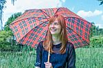 Girl With Rain Under Umbrella In Nature Stock Photo