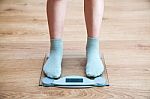 Girl's Legs Standing On The Scales Stock Photo