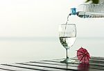 Glass Of Pure Water On A Dark Table On The Beach With A Palm Tre Stock Photo
