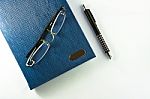 Glasses on Notebook With Pen Stock Photo