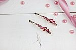 Golden Hairpins With Pink Gemstone And Pink Ribbon And Pink Pearls On White Wood Stock Photo