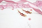 Golden Hairpins With Pink Gemstone And Pink Ribbon On Pink Background Stock Photo