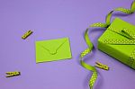 Green Gift With Green Envelope On Lilac Background Stock Photo