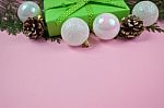 Green Gift With Polka Dot Ribbon And Christmas Decoration On Pink Background Stock Photo