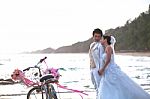 Groom And Bride Standing On Sea Beach Beside Old Classic Bicycle Stock Photo