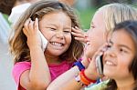 Group Of Childrens Using Mobile Phones In The Park Stock Photo