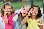Group Of Childrens Using Mobile Phones In The Park Stock Photo
