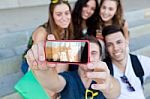 Group Of Friends Taking Photos With A Smartphone In The Street Stock Photo