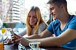 Group Of Friends Using Mobile Phone In Cafe Stock Photo