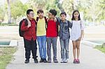 Group Of Kids Friends Arm Around Standing Having Fun And Smiling In Park Stock Photo