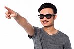 Guy In Dark Sunglasses Pointing At Something Stock Photo