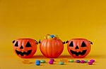 Halloween Jack O Lantern Bucket Filled With Candies On Yellow Background Stock Photo