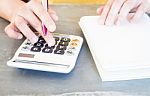 Hand Holding Pen And Pressing Calculator Buttons Stock Photo