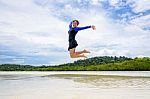 Happy Asian Teen Girl Jumping Fun On The Beach Stock Photo