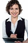 Happy Businesswoman Writing On Clipboard Stock Photo