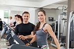 Happy Coach Assisting Young Woman In A Gym Stock Photo