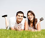 Happy Couple Lie Down On Grass Stock Photo