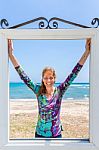 Happy Dutch Woman In Window Near Blue Sea And Beach Stock Photo