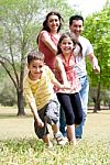 Happy Family Having Fun In The Park Stock Photo