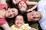 Happy Family Laying In The Circle On Green Grass Stock Photo