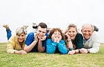 Happy Family Lying On Green Lawn Stock Photo