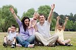Happy Family Of Five Having Fun By Raising Hands Stock Photo