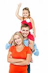 Happy Family Of Three Members Standing In Embrace Stock Photo