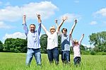 Happy Family Together Raising Their Arms Stock Photo