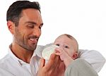 Happy Father Feeding Baby Boy With Milk Bottle Stock Photo