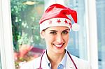 Happy Female Doctor Wearing Santa Hat Stock Photo