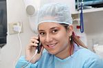 Happy Female Surgeon Using Mobile Phone Stock Photo