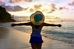 Happy Girl On The Beach At Sunrise Stock Photo