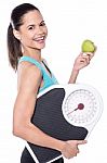 Happy Lady Posing With Weighing Scale And Apple Stock Photo