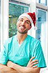 Happy Male Surgeon Wearing Santa Hat Stock Photo