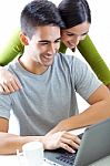 Happy Young Couple Browsing Internet At Home Stock Photo