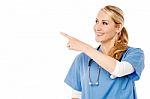 Happy Young Female Doctor Pointing Away Stock Photo