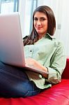 Happy Young Woman Using Laptop On Sofa Stock Photo