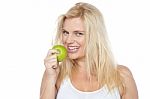 Health Conscious Woman About To Take Bite From Green Apple Stock Photo