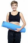Health Conscious Woman Holding Blue Exercise Mat Stock Photo