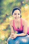 Healthy Woman - Girl Smiling And Leaning Fitness Ball, Blurred Bokeh Abstract Light Spring Forest Background Stock Photo