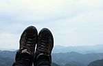 Hiking Shoes In The Mountains And Sky Background Stock Photo