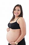 Hispanic Pregnant Woman Smiling And Touching Her Belly Stock Photo
