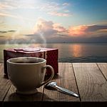 Hot Coffee And Gift Box On Wooden Table With Seascape Stock Photo