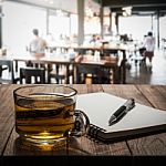 Hot Tea With Notebook And Pen On Wooden Table Stock Photo