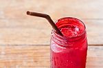 Iced Drink In Red Glass On Wooden Table Stock Photo
