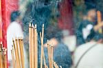 Incense Stick Burning Slowly With Fragrant Smell Smoke. People Praying On Chinese Buddhist Temple On Chinese New Year, Luna New Year Stock Photo